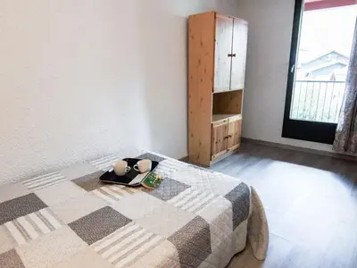 a bedroom with a bed with a blanket and a cabinet at Apartment Gentiane-3 by Interhome in Chamonix-Mont-Blanc