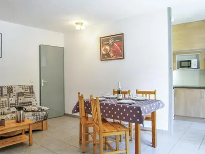 a dining room with a table and chairs and a kitchen at Apartment Gentiane-3 by Interhome in Chamonix-Mont-Blanc