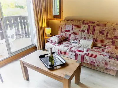 a living room with a couch and a table at Apartment Clos du Savoy-15 by Interhome in Chamonix-Mont-Blanc