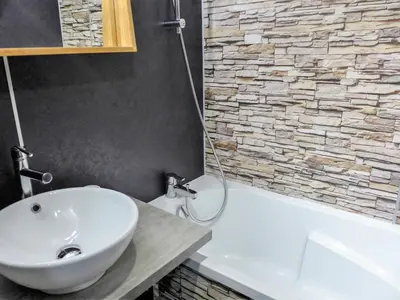 a bathroom with a white sink and a bath tub at Apartment Clos du Savoy-15 by Interhome in Chamonix-Mont-Blanc