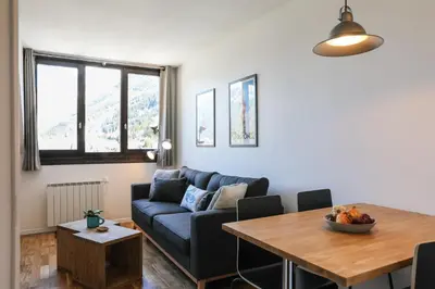 a living room with a blue couch and a table at Apartment Chamois Blanc 7A - Great views of Chamonix in Chamonix-Mont-Blanc