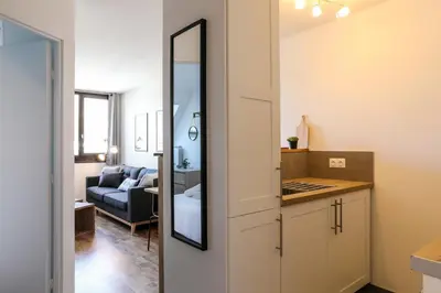 a kitchen with a mirror and a living room at Apartment Chamois Blanc 7A - Great views of Chamonix in Chamonix-Mont-Blanc