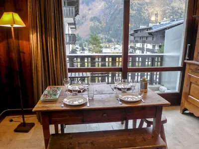 a table with wine glasses on top of a balcony at Apartment Le Brévent-14 by Interhome in Chamonix-Mont-Blanc