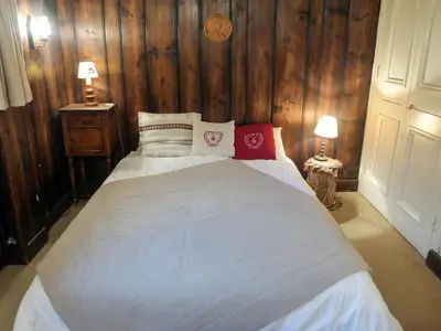 a bedroom with a large bed with wooden walls at Apartment Le Brévent-14 by Interhome in Chamonix-Mont-Blanc