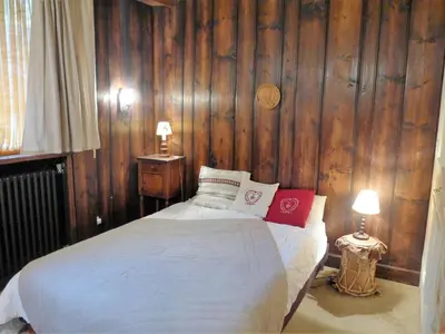 a bedroom with a bed with wood paneled walls at Apartment Le Brévent-14 by Interhome in Chamonix-Mont-Blanc
