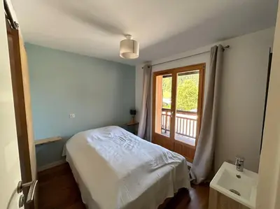 a bedroom with a bed and a window and a sink at Chalet Les Contamines in Les Contamines-Montjoie