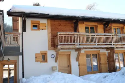 a house with a deck on the side of it at Chalet Les Contamines in Les Contamines-Montjoie