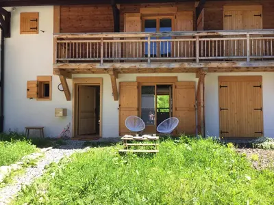 two chairs on a table in front of a house at Chalet Les Contamines in Les Contamines-Montjoie