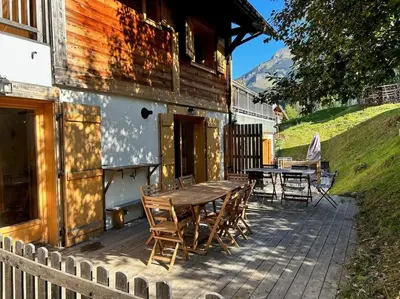 a wooden table and chairs on a patio at Chalet Les Contamines in Les Contamines-Montjoie