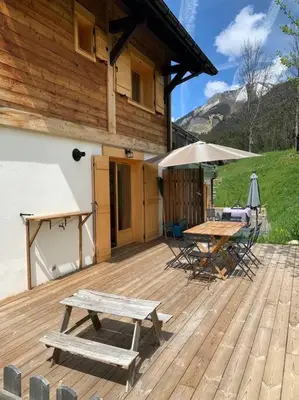 a wooden deck with a picnic table and an umbrella at Chalet Les Contamines in Les Contamines-Montjoie