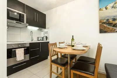 a kitchen with a wooden table and chairs in a room at Apartment Grepon 2 - A Chamonix Alpine Haven in Chamonix-Mont-Blanc