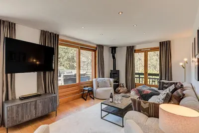 a living room with a couch and a flat screen tv at Les Melées Apartments - Alpes Travel - Argentiere in Chamonix-Mont-Blanc