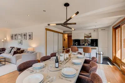 a dining room and living room with a table and chairs at Les Melées Apartments - Alpes Travel - Argentiere in Chamonix-Mont-Blanc