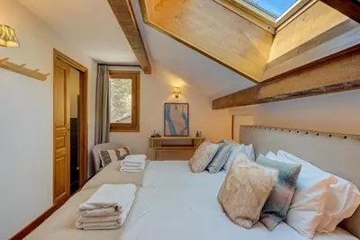 a bedroom with a large white bed with a skylight at Les Melées Apartments - Alpes Travel - Argentiere in Chamonix-Mont-Blanc