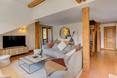 a living room with a couch and a tv at Les Melées Apartments - Alpes Travel - Argentiere in Chamonix-Mont-Blanc