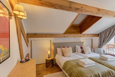two beds in a room with wooden ceilings at Les Melées Apartments - Alpes Travel - Argentiere in Chamonix-Mont-Blanc