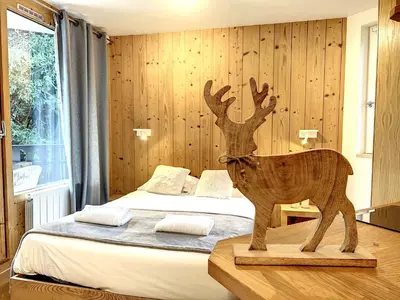 a wooden statue of a deer in a bedroom at Le Caribou in Chamonix-Mont-Blanc