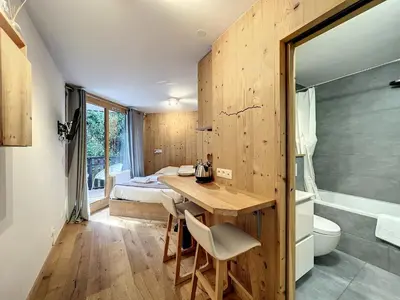 a room with a desk and a bed and a bathroom at Le Caribou in Chamonix-Mont-Blanc