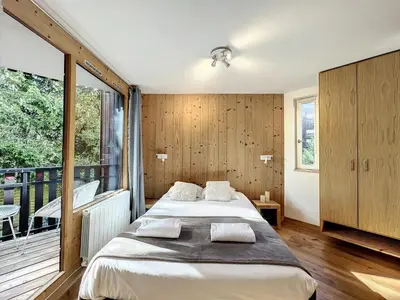 a bedroom with a bed and a balcony at Le Caribou in Chamonix-Mont-Blanc