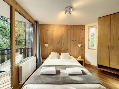 a bedroom with a large bed and a large window at Le Caribou in Chamonix-Mont-Blanc