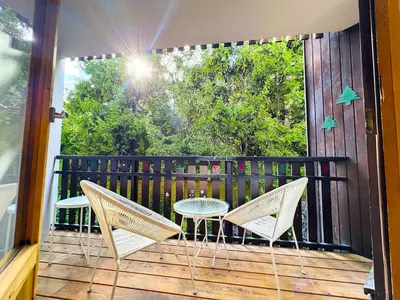a patio with two chairs and a table on a deck at Le Caribou in Chamonix-Mont-Blanc