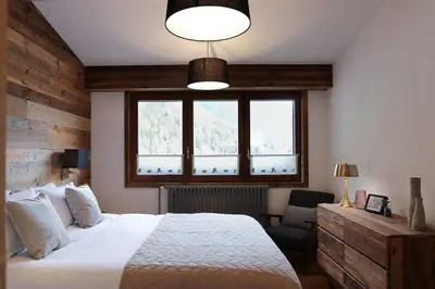 a bedroom with a white bed and a window at Le Brevent 1 Apartment in Chamonix-Mont-Blanc