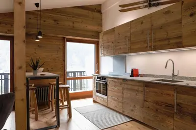 a kitchen with wooden cabinets and a table with a counter at Le Brevent 1 Apartment in Chamonix-Mont-Blanc