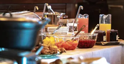 a table with bowls of food on a table at Hôtel Les Servages d'Armelle in Les Carroz d'Araches