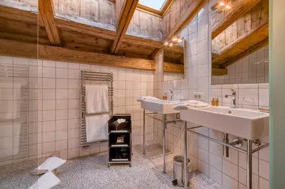 a bathroom with two sinks and a wooden ceiling at Hôtel Les Servages d'Armelle in Les Carroz d'Araches