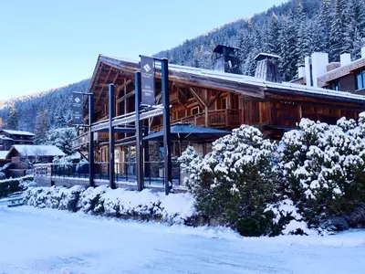 a ski lodge with snow on the ground in front of it at Hôtel Les Servages d'Armelle in Les Carroz d'Araches