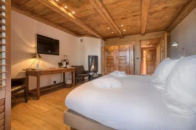 a bedroom with a bed and a desk and a television at Hôtel Les Servages d'Armelle in Les Carroz d'Araches