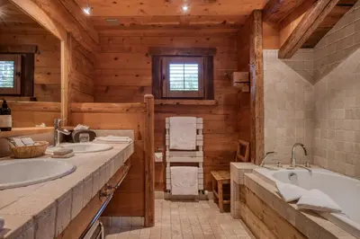 a bathroom with two sinks and a tub at Hôtel Les Servages d'Armelle in Les Carroz d'Araches