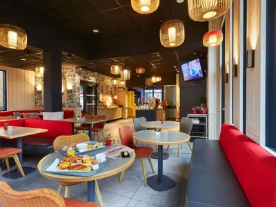 a restaurant with tables and chairs with food on them at Ibis Sallanches Porte du MontBlanc in Sallanches