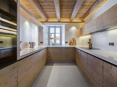 a large kitchen with wooden cabinets and a wooden ceiling at Appartement rénové 3 ch, centre Megève, parking, wifi - FR-1-453-178 in Megève