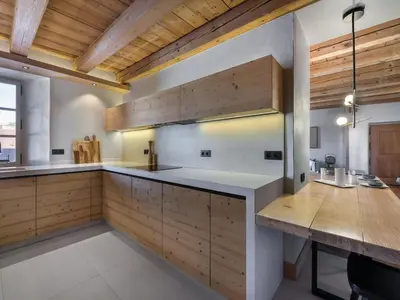 a kitchen with wooden cabinets and a wooden table at Appartement rénové 3 ch, centre Megève, parking, wifi - FR-1-453-178 in Megève