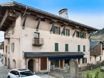 a building with a car parked in front of it at Appartement rénové 3 ch, centre Megève, parking, wifi - FR-1-453-178 in Megève