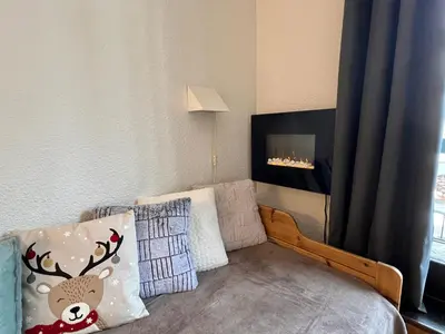 a small bedroom with a bed with a fireplace at Le Balme Studio WiFi/Parking/Balcony in Chamonix-Mont-Blanc