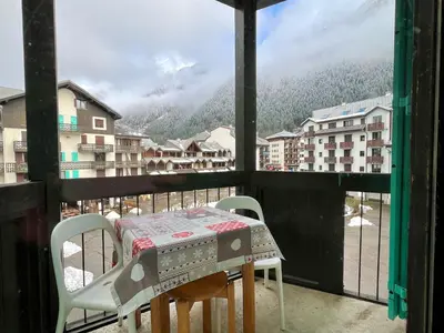 a table and chairs on a balcony with a view at Le Balme Studio WiFi/Parking/Balcony in Chamonix-Mont-Blanc