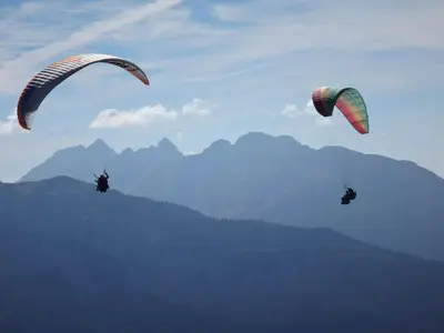 two people are flying kites in the sky at Chalet Les Trappeurs in Les Carroz d'Araches