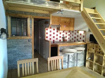 a small kitchen with wooden cabinets and a staircase at Le Nant in Les Contamines-Montjoie
