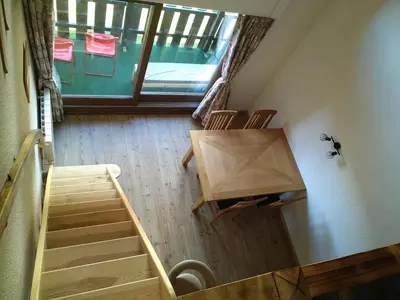 an attic room with a staircase and a window at Le Nant in Les Contamines-Montjoie