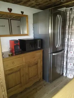 a kitchen with a stainless steel refrigerator and a microwave at Le Nant in Les Contamines-Montjoie