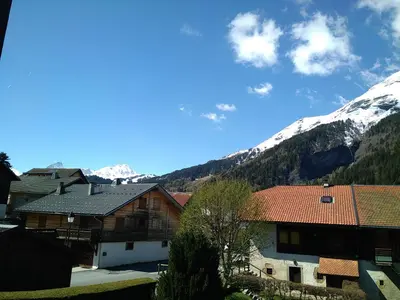 a group of buildings with snow capped mountains in the background at Le Nant in Les Contamines-Montjoie