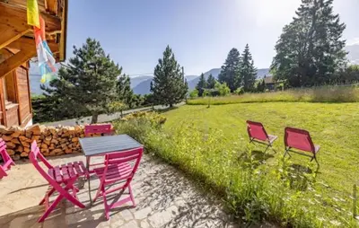 a group of red chairs and a table in a yard at Marie Mont Blanc vue Mont Blanc in Saint-Gervais-les-Bains