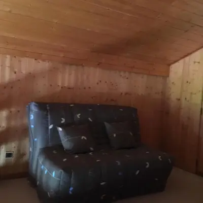 a black leather couch in a room with a wooden ceiling at CHALET DES NEIGES in Les Carroz d'Araches