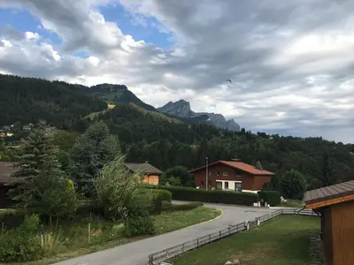a kite is flying in the sky over a mountain at CHALET DES NEIGES in Les Carroz d'Araches