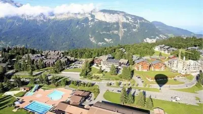 a view of a resort with a mountain in the background at CHALET DES NEIGES in Les Carroz d'Araches