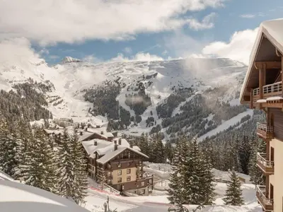 a ski lodge in the mountains with snow on the ground at Flaine prime ski in, ski out Apartment in Flaine