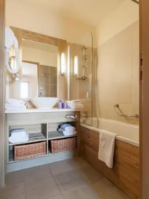 a bathroom with a sink and a tub and a mirror at Flaine prime ski in, ski out Apartment in Flaine