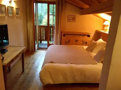 a bedroom with a bed and a desk and a television at Chalet Altitude 1057 in Chamonix-Mont-Blanc